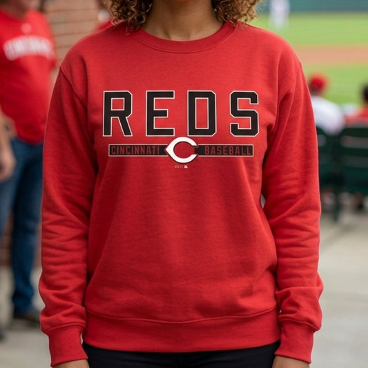 Woman wearing a red 'REDS' sweatshirt at a baseball game