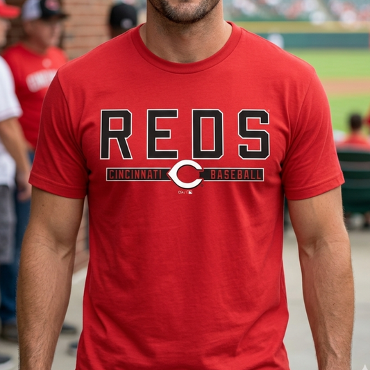 Man wearing a red 'REDS' t-shirt with a baseball field in the background