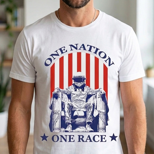 A smiling man wearing a white graphic t-shirt with a red and blue patriotic design that reads 'ONE NATION ONE RACE' and features a stylized figure seated in a chair.